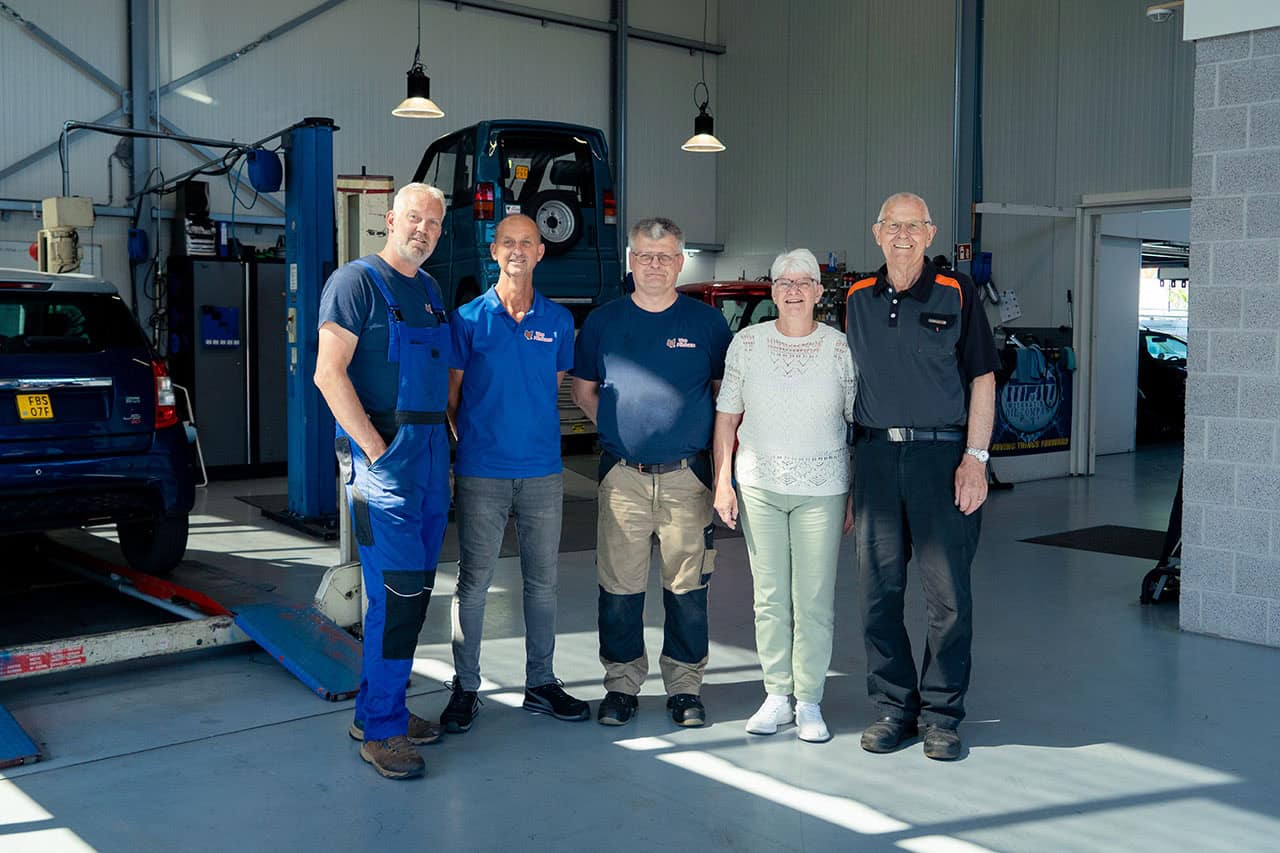 Werkplaats van Vos Minicars met monteurs en klanten, specialisten in kleine autos en elektrische voertuigen, professionele autoreparatie en onderhoud, betrouwbaar en vriendelijk service.
