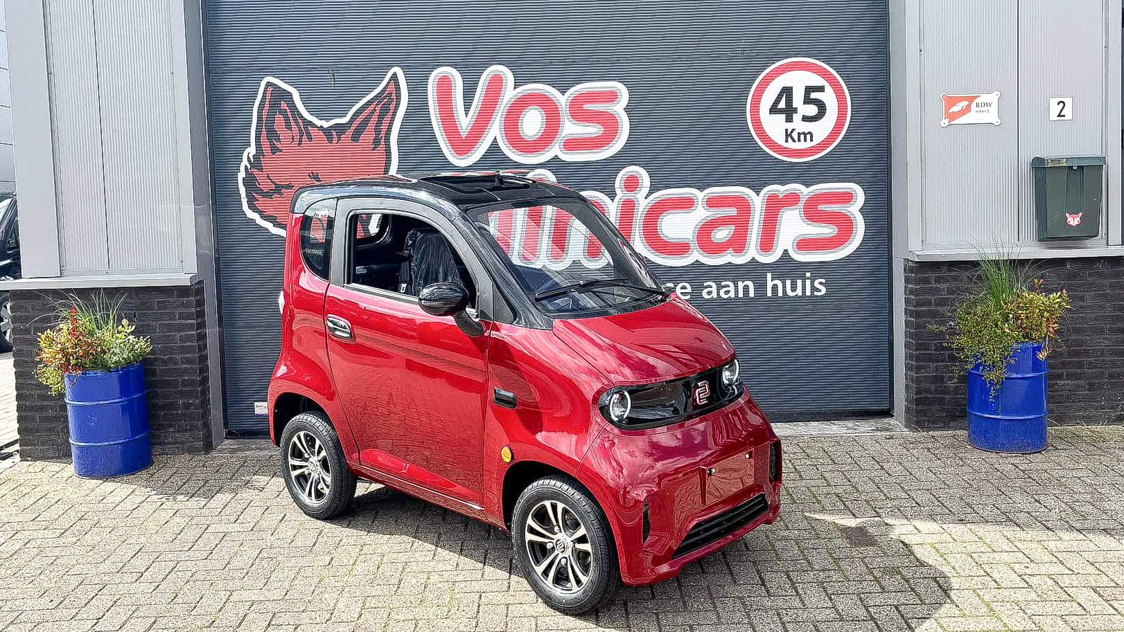 Kleine rode elektrische stadsauto voor volwassenen, ideaal voor in de stad en korte afstanden.