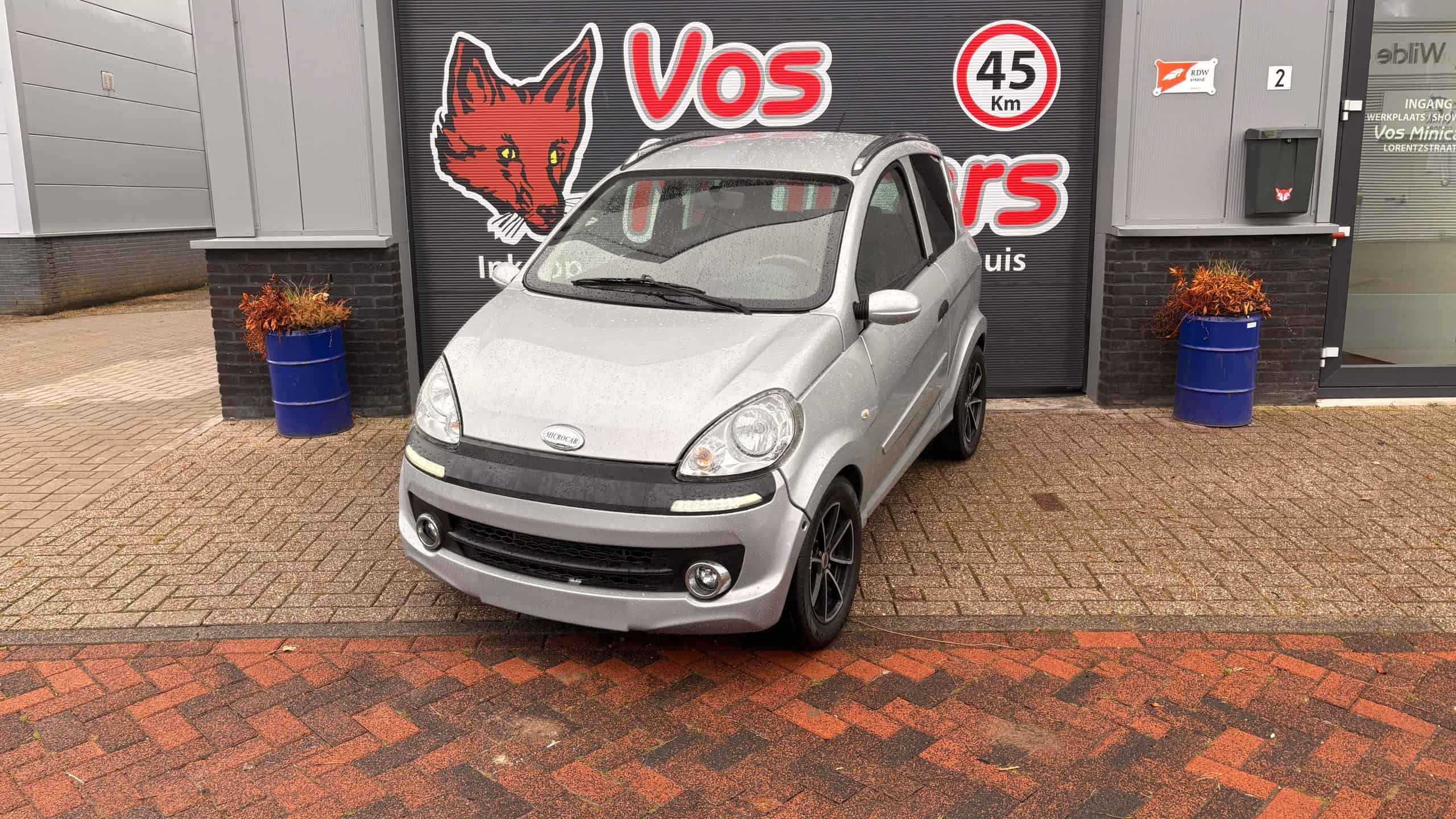 Microcar occasion in grijs, compacte stadsauto met black wheels en leren interieur, ideaal voor urban rijden en parkeren.