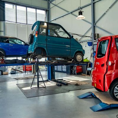 Kleine elektrische auto's worden in een werkplaats gerepareerd en onderhouden.
